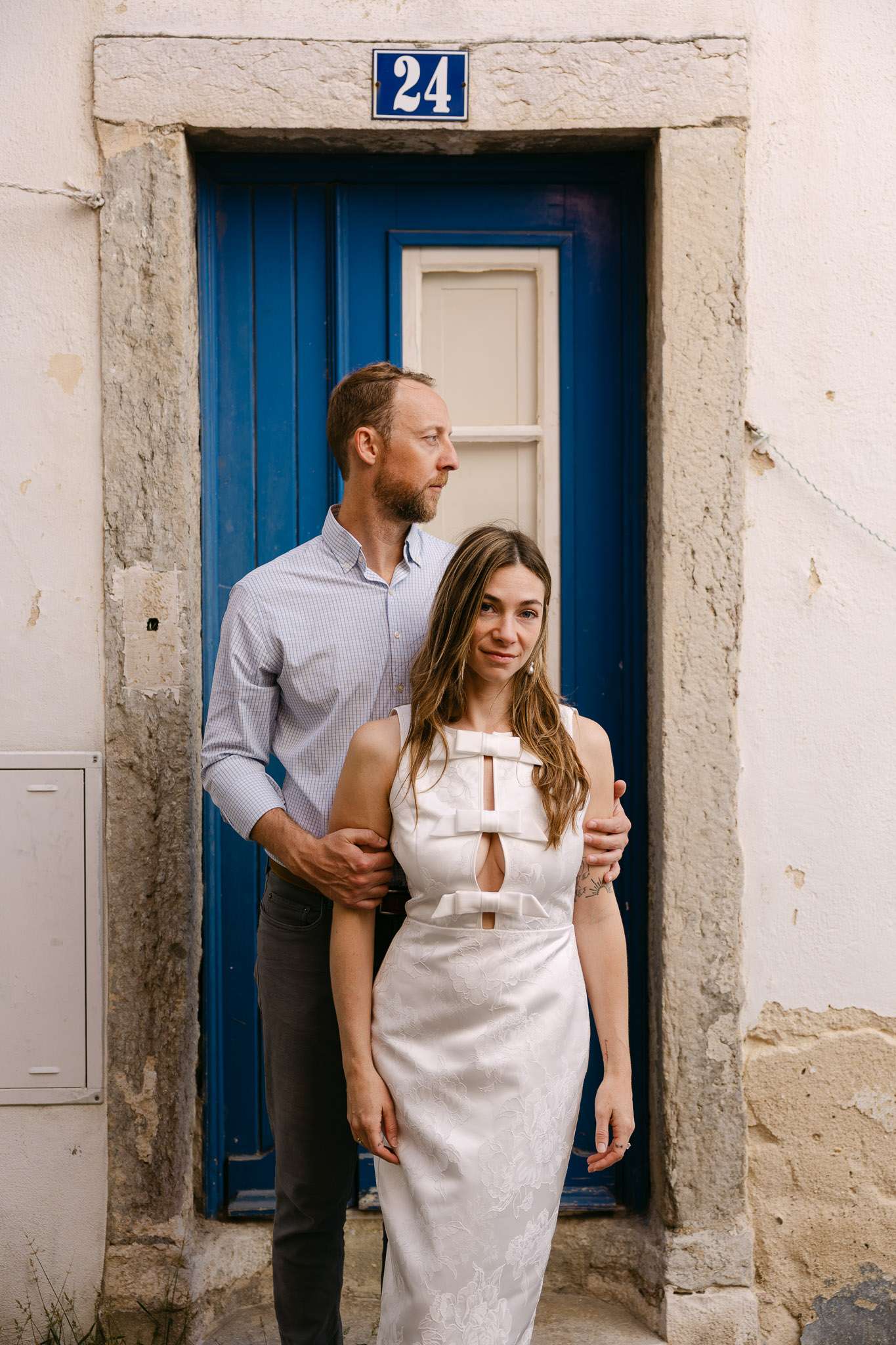 Engaged couple portrait in front of blue door number 24 in Alfama Lisbon, save the date photos, documentary photographer