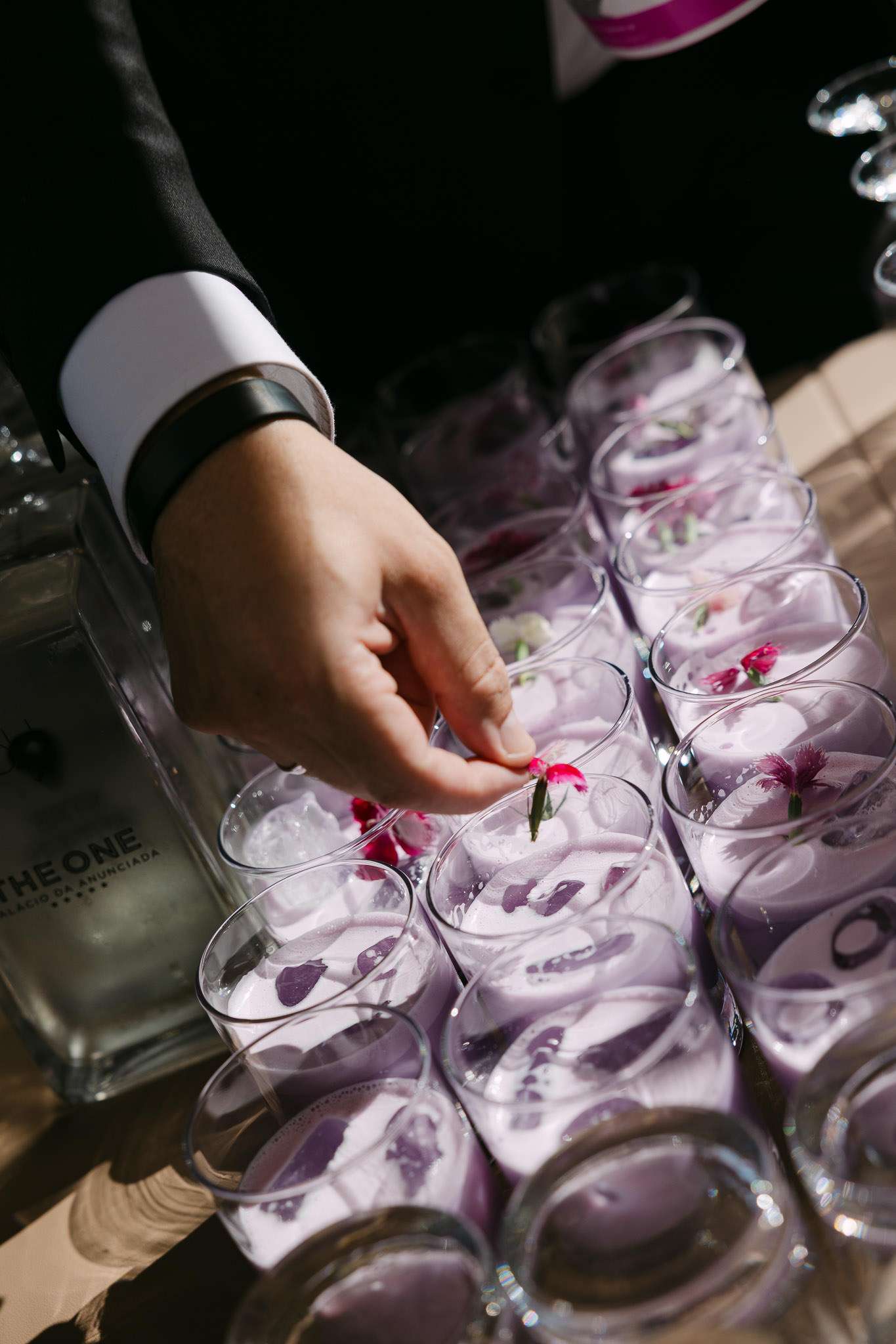 Bartender placing flower garnish into lavender cocktails at Palácio da Anunciada wedding reception, documentary wedding photography Lisbon