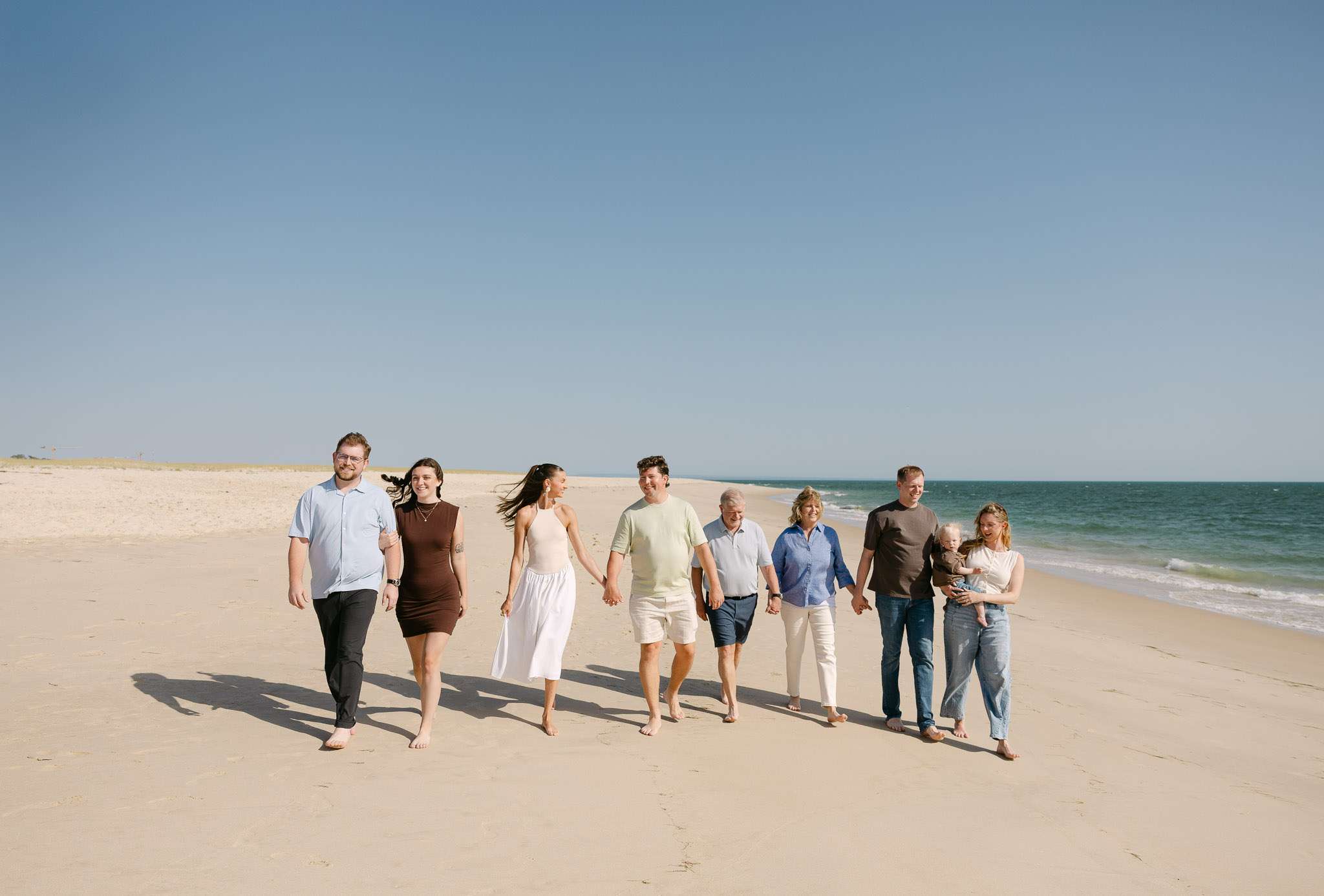 Multigenerational family with baby walking wide Comporta beach, family photography session Portugal