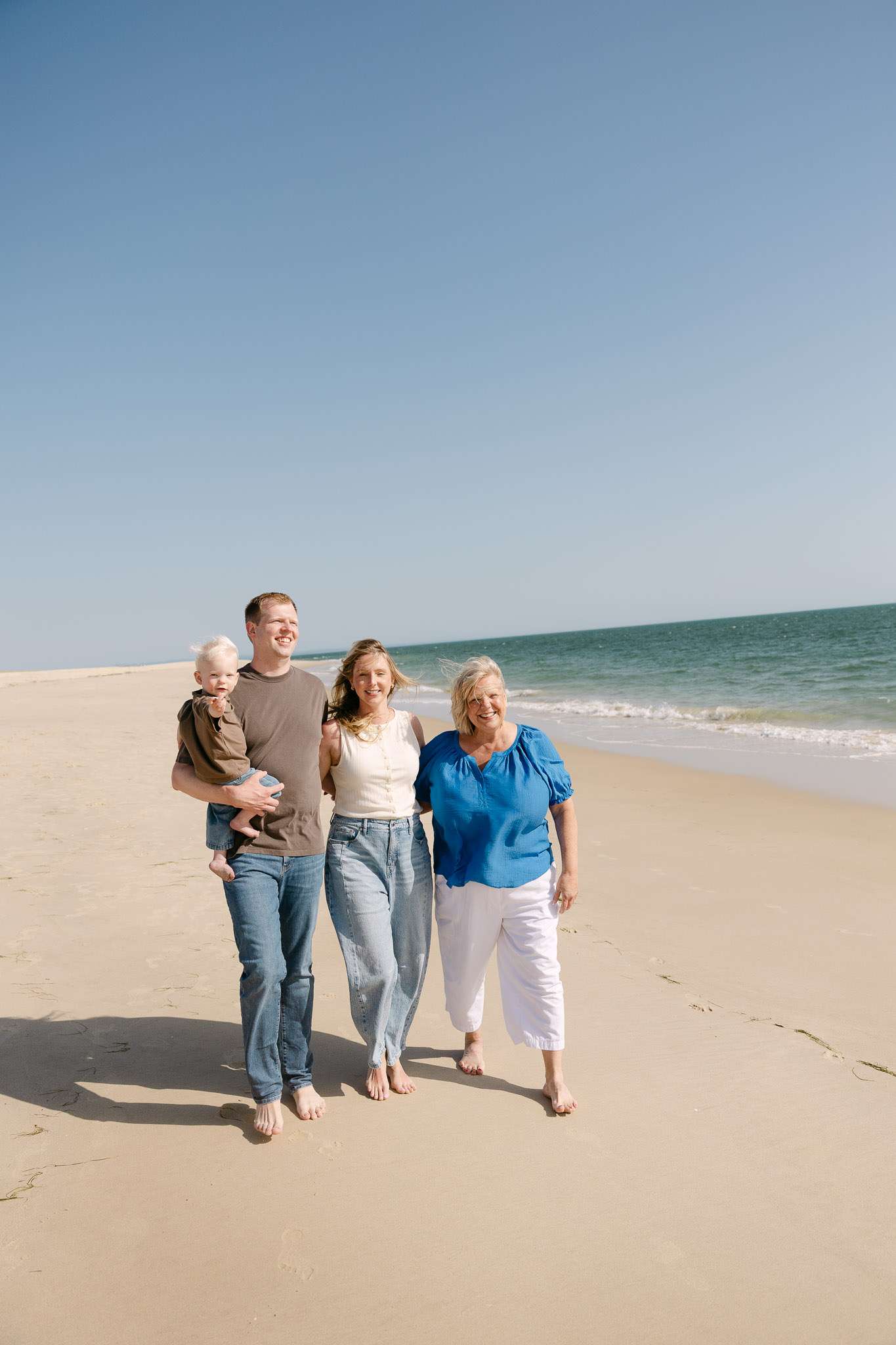 Grandmother son and first grandchild walking Comporta beach, three-generation documentary family photography Portugal