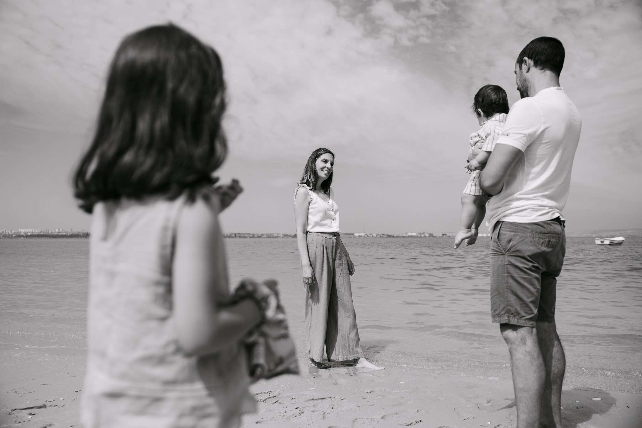 lack and white documentary photo of a young family on a beach by the Sado estuary, family photographer Setúbal Palmela Lisboa